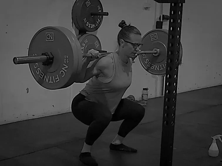 Member back squatting under coach supervision at Altona North Training