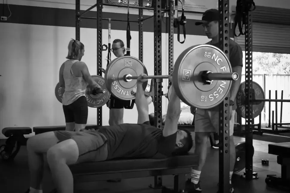 Member bench pressing with a spotter