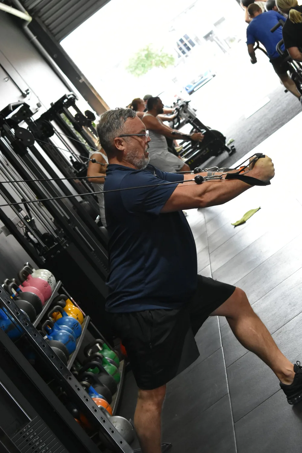 Older member performing a cable row with coaching