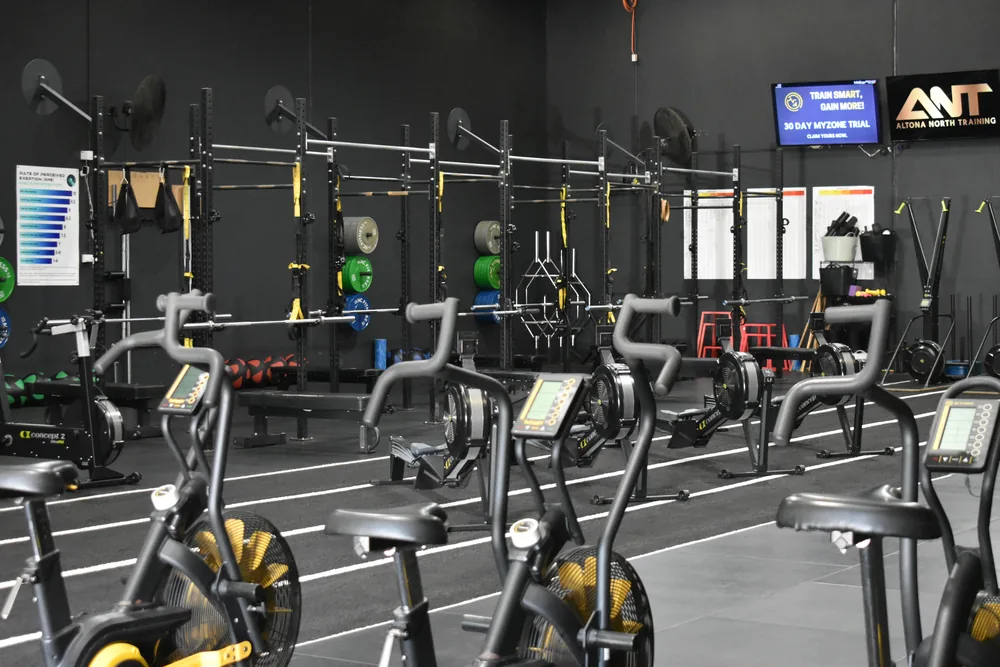 Wide view of the ANT gym floor with rowers, bikes and racks