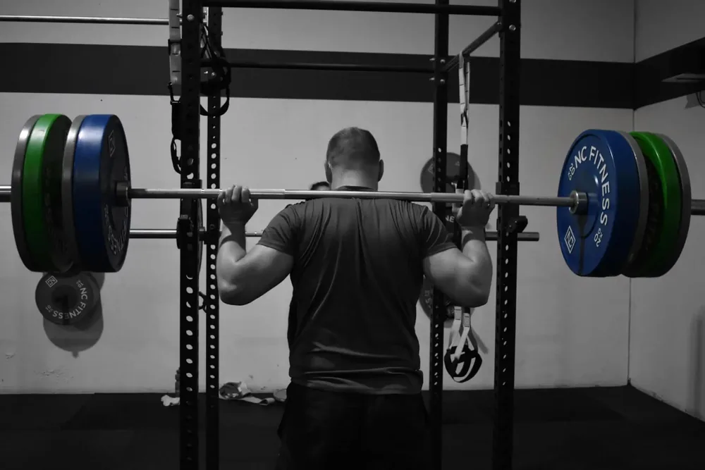Member back squatting in the ANT rack