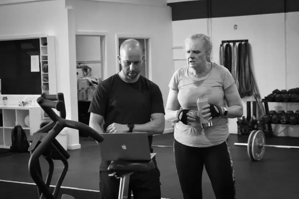 ANT coach and member reviewing a training plan on a laptop