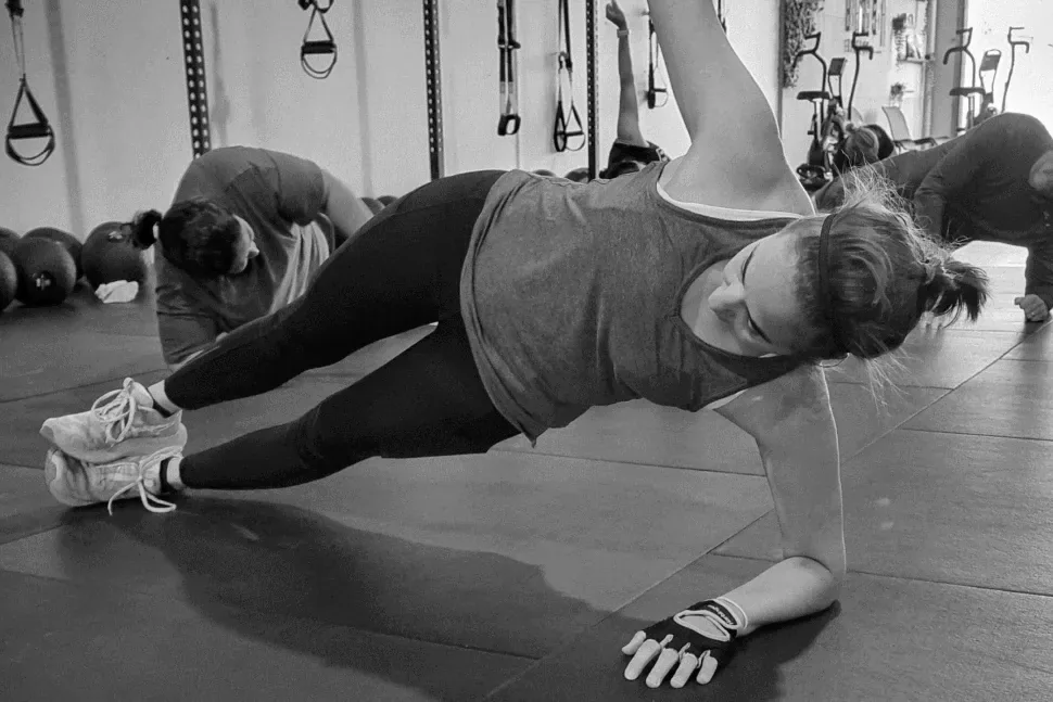 New member holding a side plank in a coached ANT session